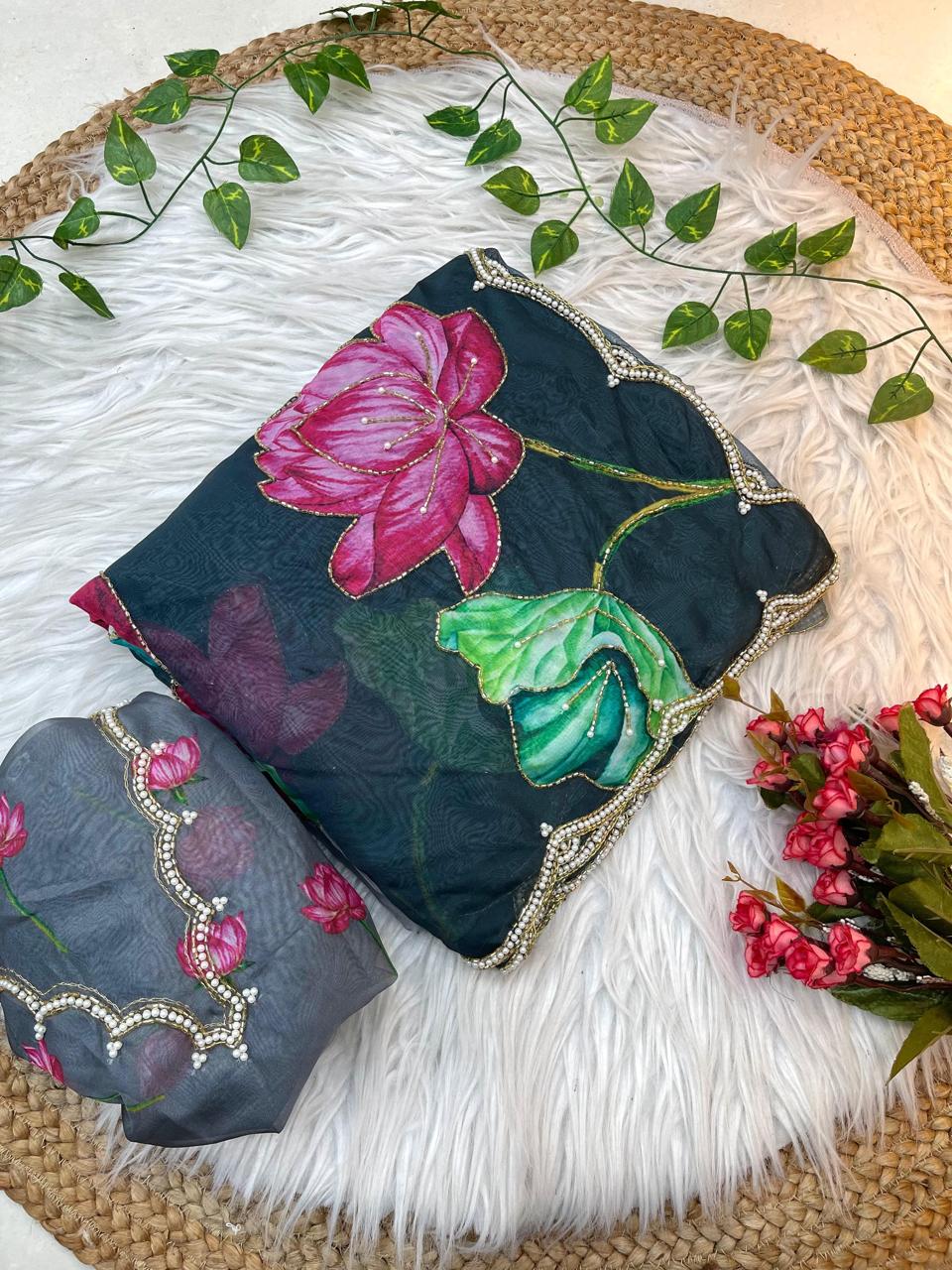 A feminine soft organza saree decorated with multicolor lotus motifs and bordered with pearl scalloped lace. Paired with a matching blouse, this saree is perfect for festive celebrations and elegant gatherings.