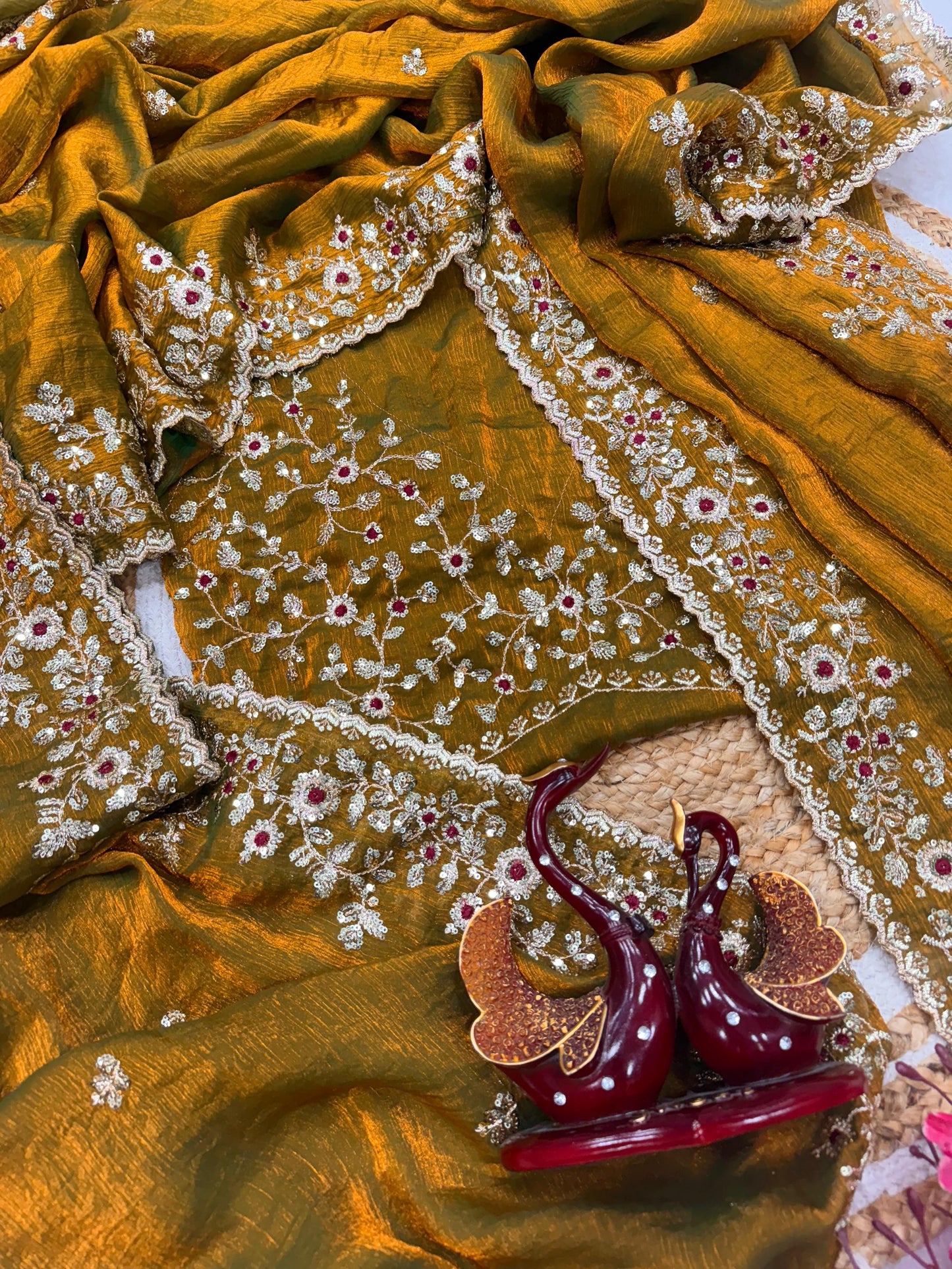 An antique gold Fandy silk saree showcasing fine hand embroidery in gold and red threadwork. The scalloped border and rich fabric texture highlight timeless craftsmanship and traditional beauty.