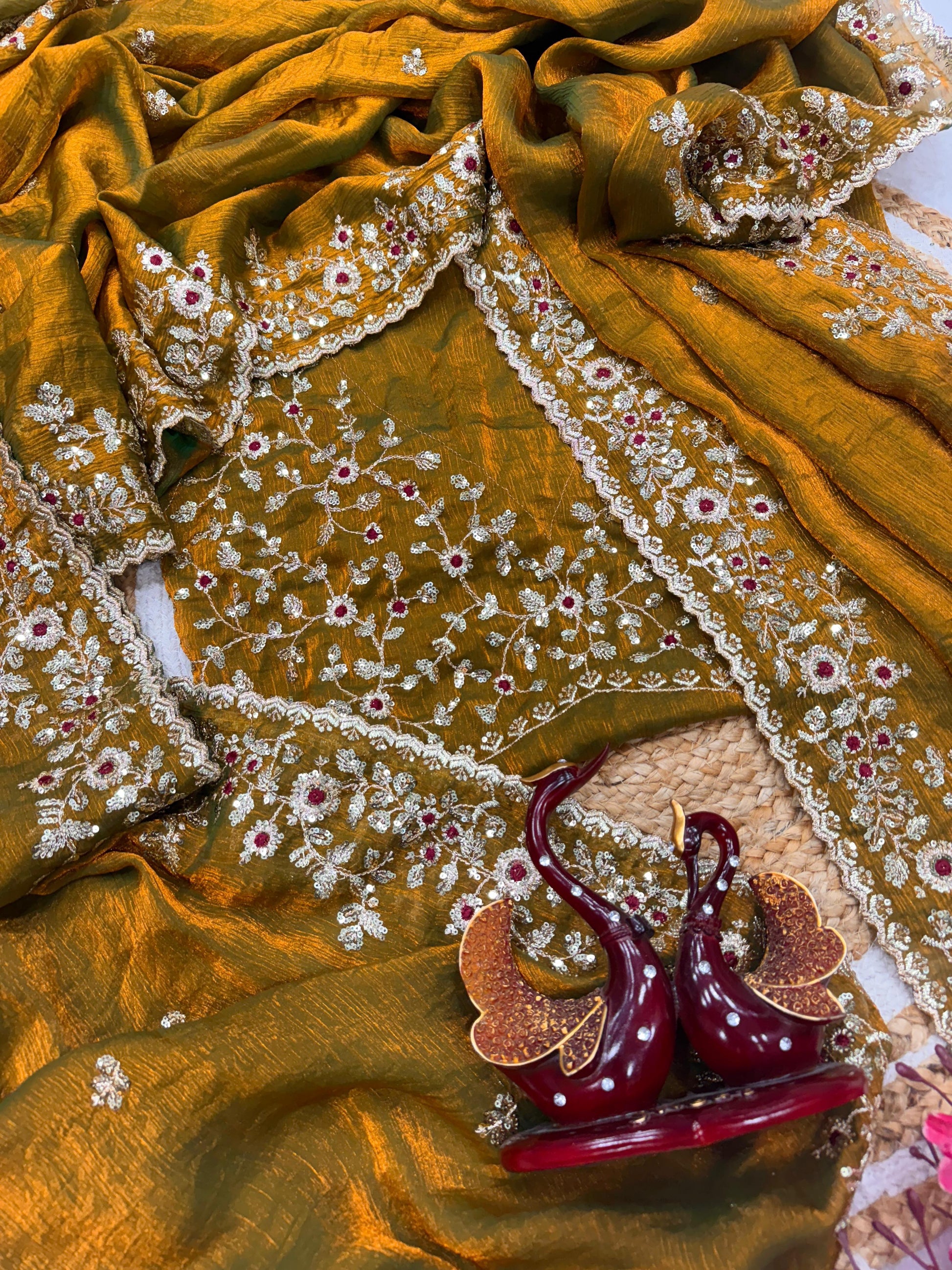 An antique gold Fandy silk saree showcasing fine hand embroidery in gold and red threadwork. The scalloped border and rich fabric texture highlight timeless craftsmanship and traditional beauty.