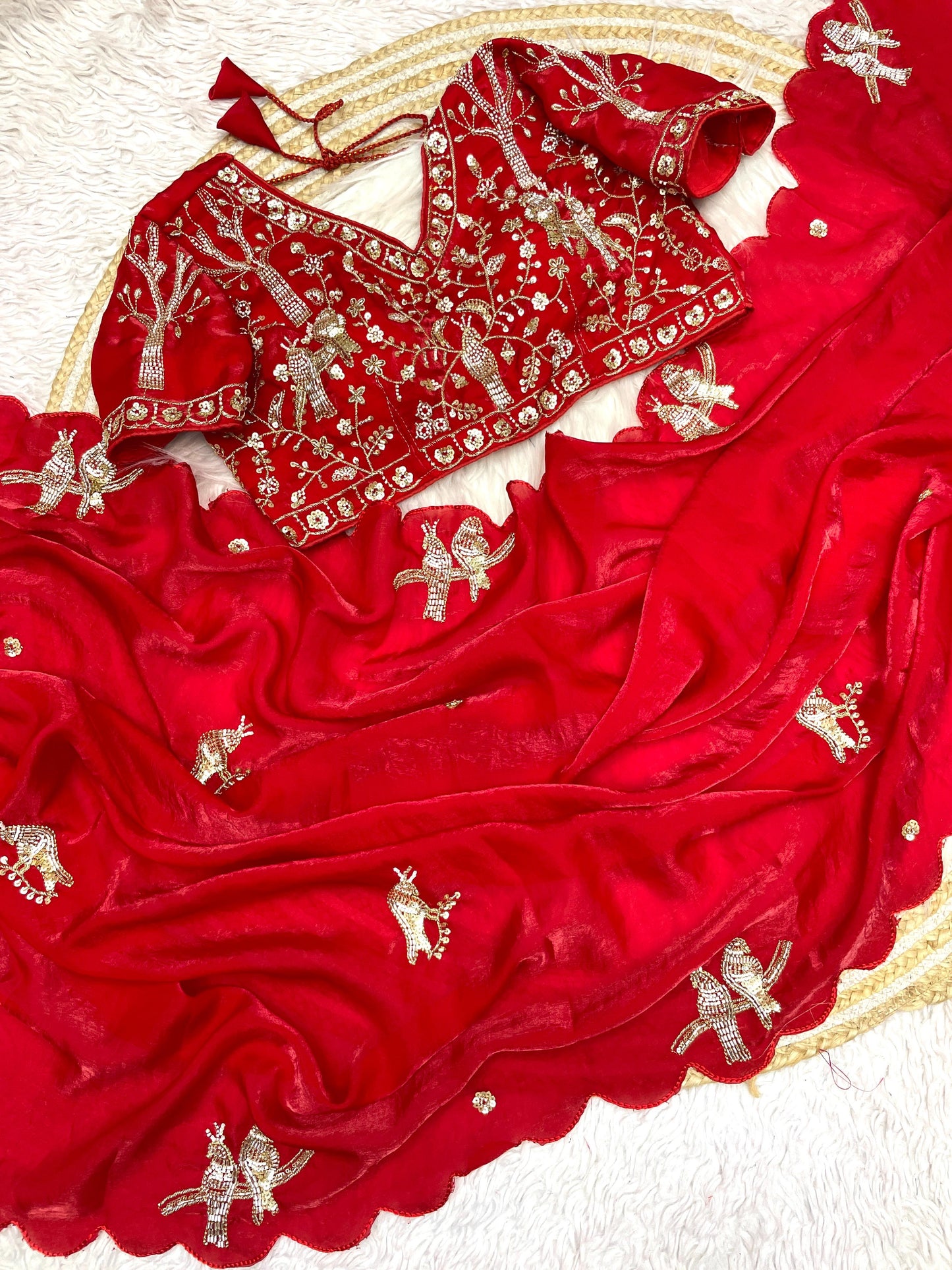 A bridal red space silk saree beautifully handcrafted with intricate bird embroidery and sequin embellishments. The matching blouse enhances its royal appeal, making it perfect for weddings and celebrations.