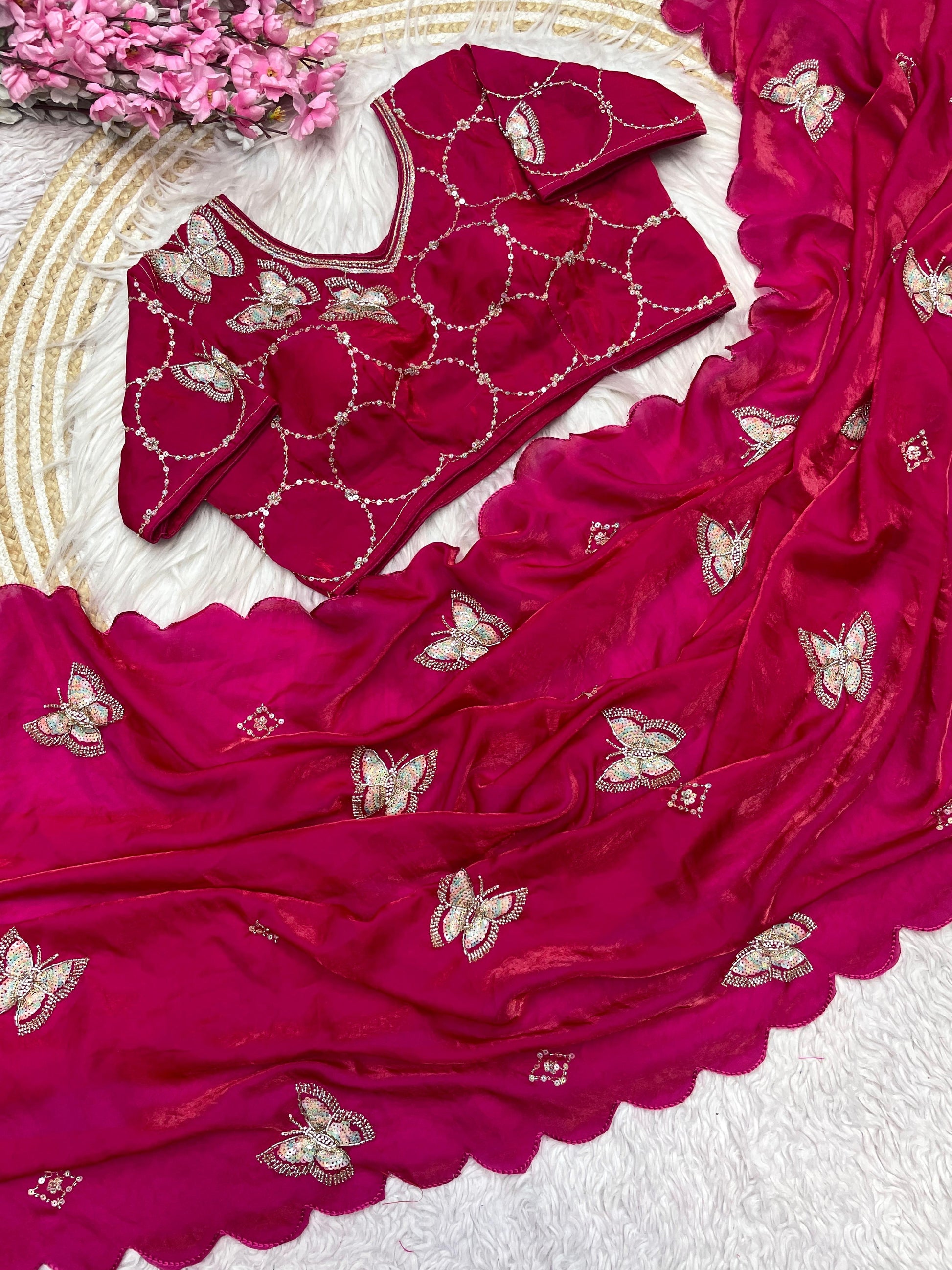 A bright Rani-colored space silk saree featuring heavy golden and silver butterfly embroidery. The saree is paired with a matching embroidered blouse, exuding a regal and luxurious bridal charm.