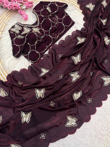 A deep maroon space silk saree decorated with delicate butterfly sequin embroidery and soft scalloped borders. The matching blouse features circular embroidered patterns, offering a trendy and sophisticated appeal.