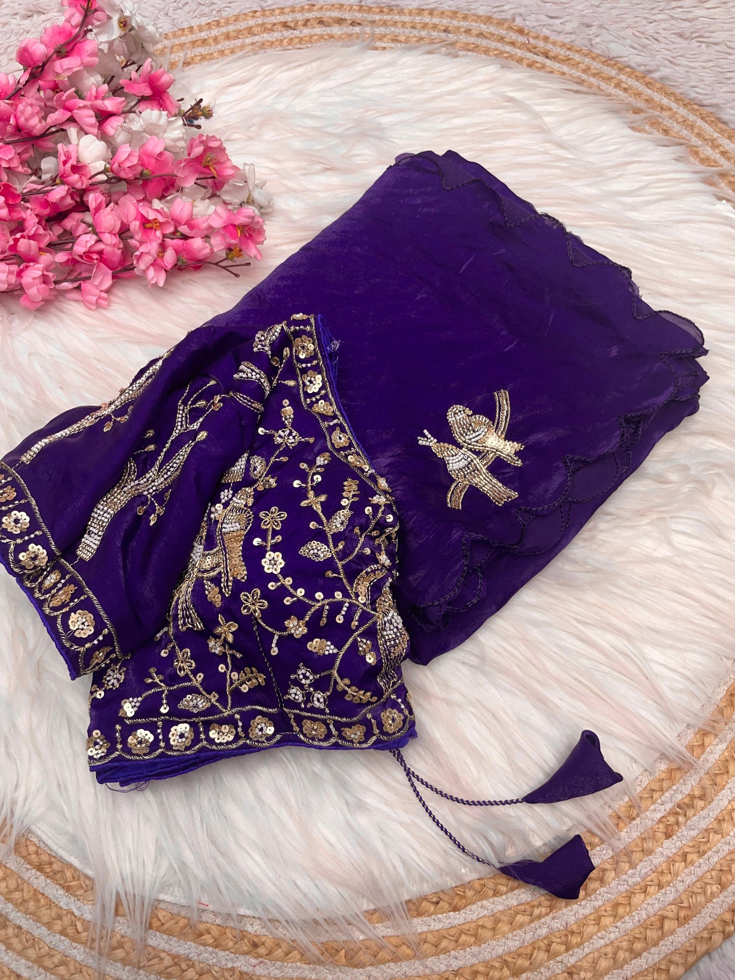 A luxurious purple space silk saree beautifully embellished with zari and sequin bird motifs. The heavily embroidered blouse with golden detailing complements the saree’s rich texture, making it ideal for weddings and festive occasions.