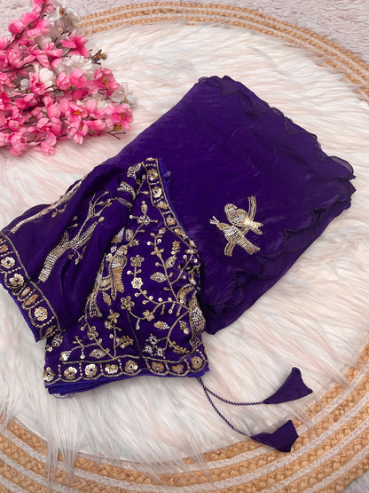 A luxurious purple space silk saree beautifully embellished with zari and sequin bird motifs. The heavily embroidered blouse with golden detailing complements the saree’s rich texture, making it ideal for weddings and festive occasions.