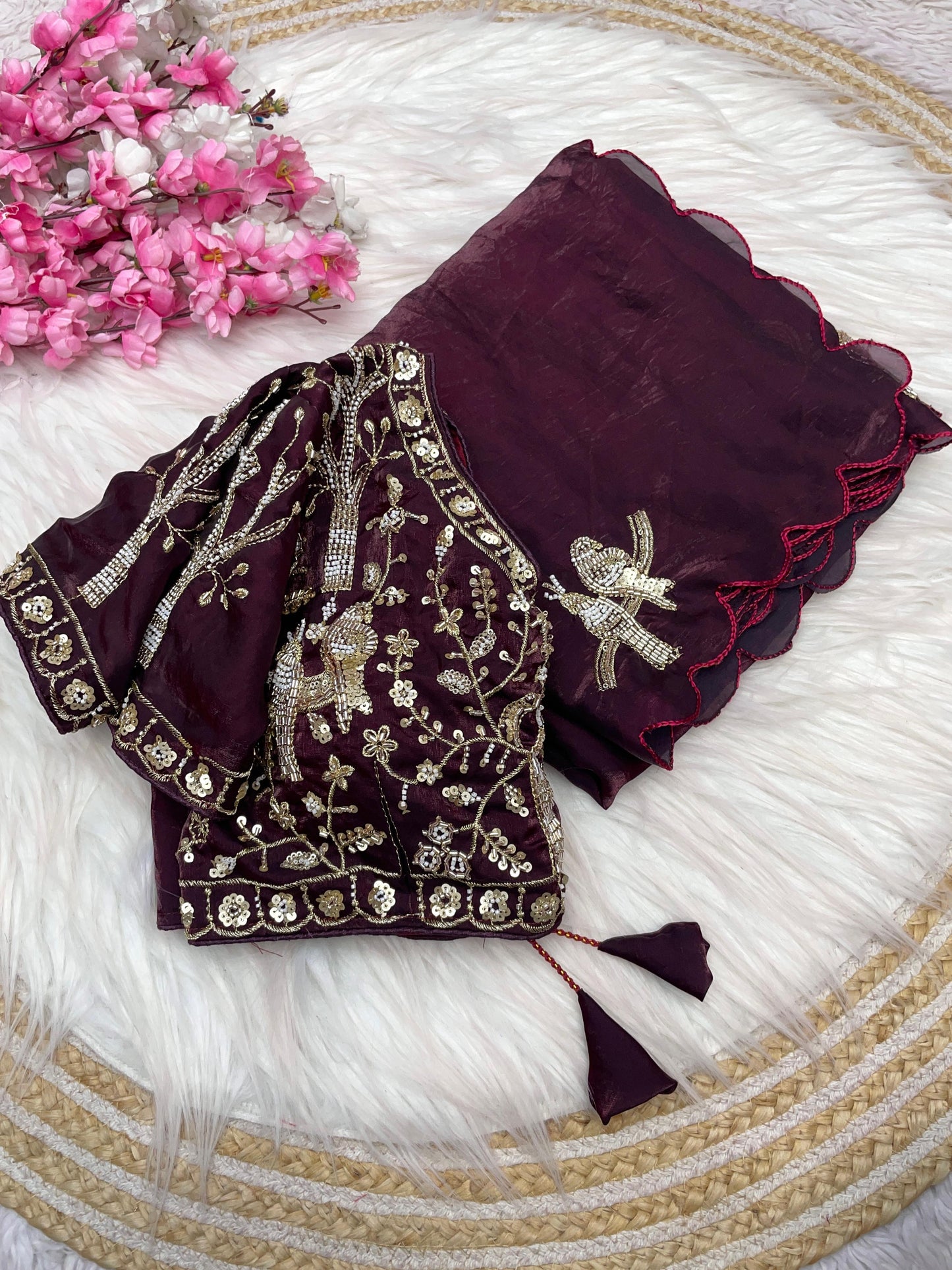 A luxurious maroon space silk saree decorated with fine zari and sequin bird embroidery. The matching stitched blouse showcases detailed embroidery, giving the outfit a royal and bridal appeal ideal for weddings and receptions.