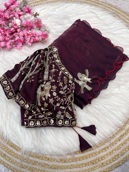A luxurious maroon space silk saree decorated with fine zari and sequin bird embroidery. The matching stitched blouse showcases detailed embroidery, giving the outfit a royal and bridal appeal ideal for weddings and receptions.