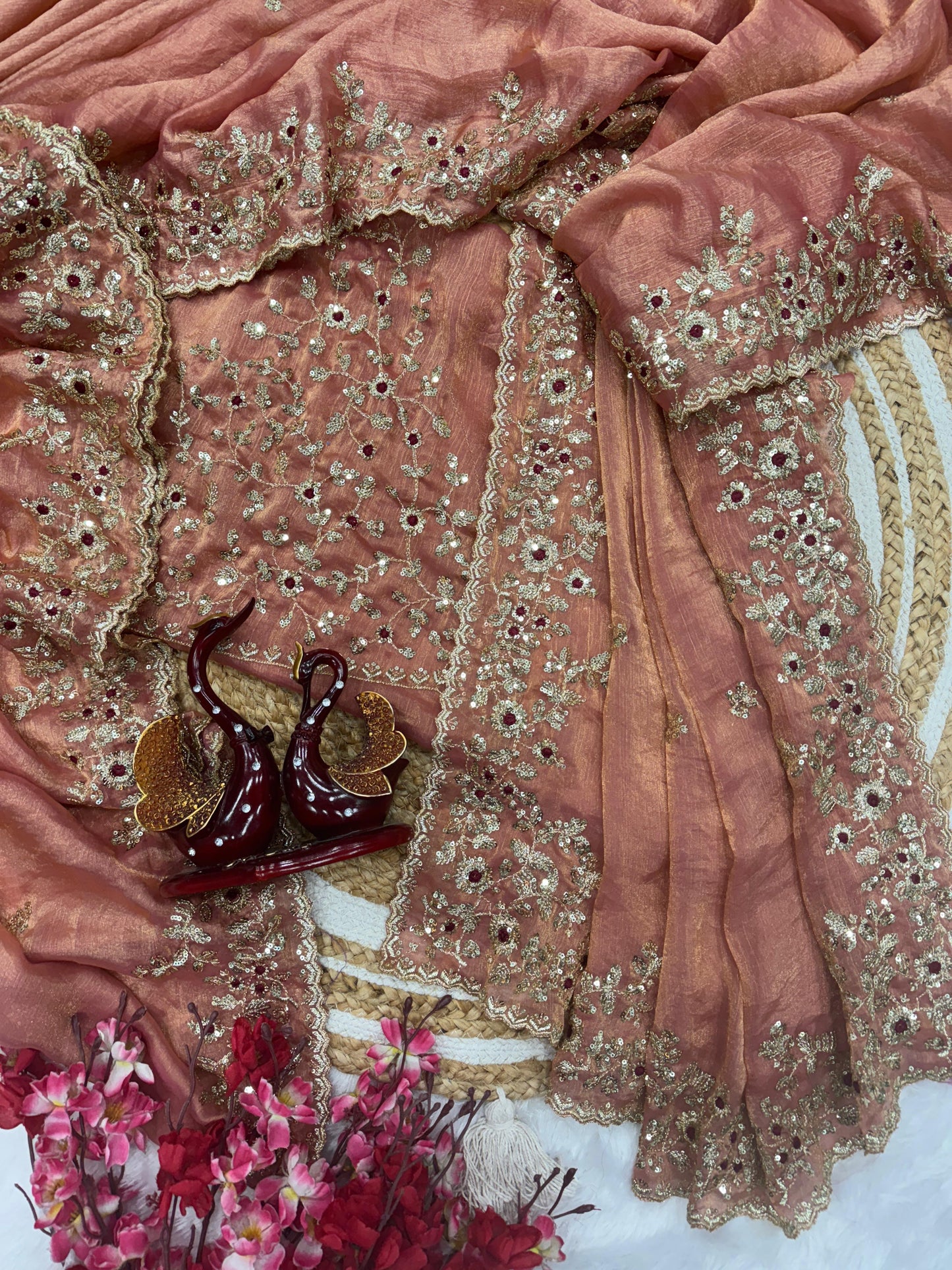 A designer peach Fandy silk saree beautifully embellished with heavy golden zari embroidery and floral motifs. The matching blouse piece completes the regal look, perfect for festive and wedding occasions.