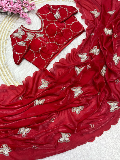 A luxurious red space silk saree decorated with elegant sequin-embroidered butterfly motifs and a scalloped border. The ensemble includes a matching stitched blouse with circular embroidered patterns, exuding bridal elegance and festive sophistication.