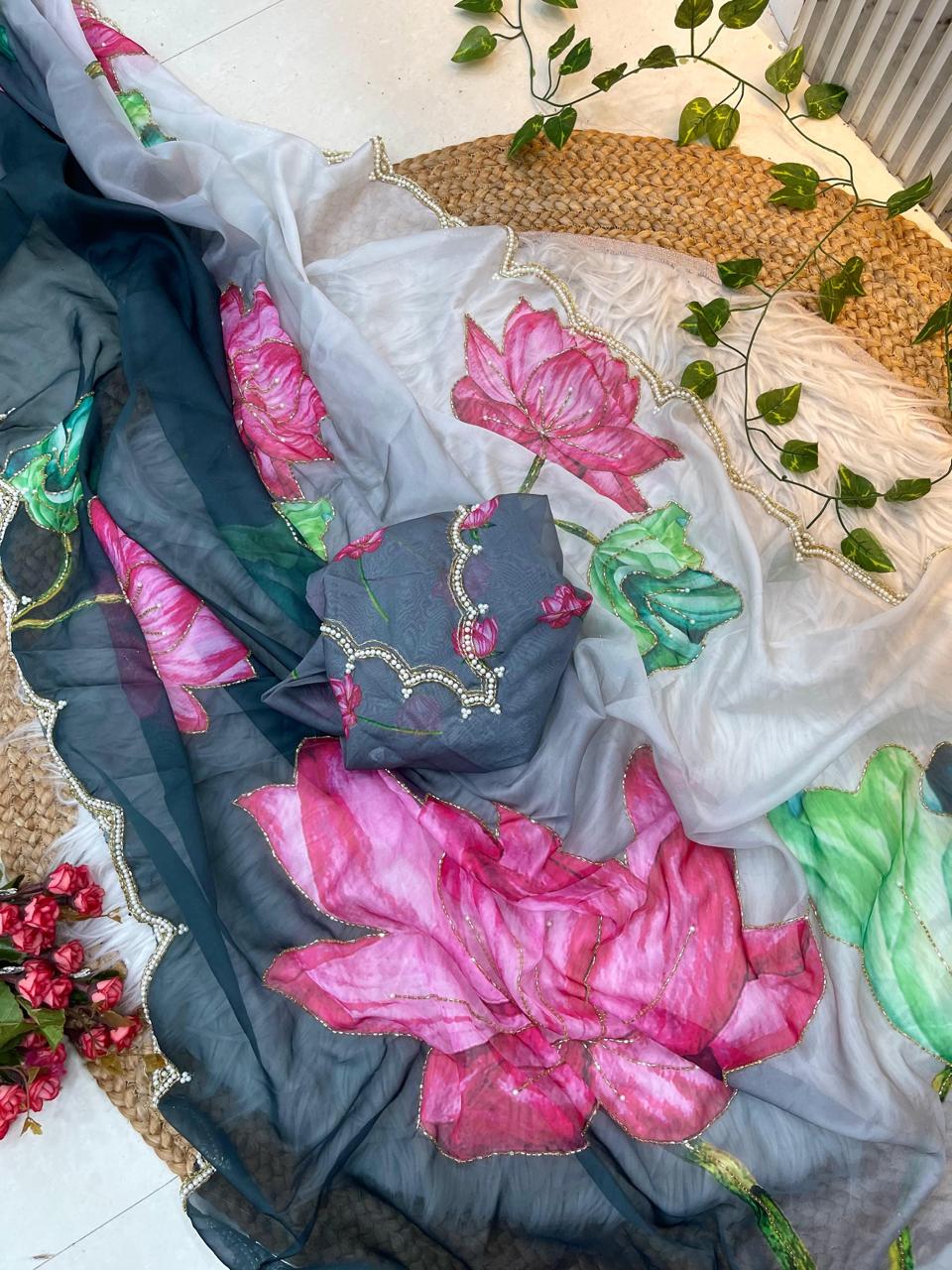 A stylish dual-tone soft organza saree in grey and white, enriched with vibrant lotus floral prints. The pearl scalloped edging and matching printed blouse add sophistication to this trendy and modern saree.