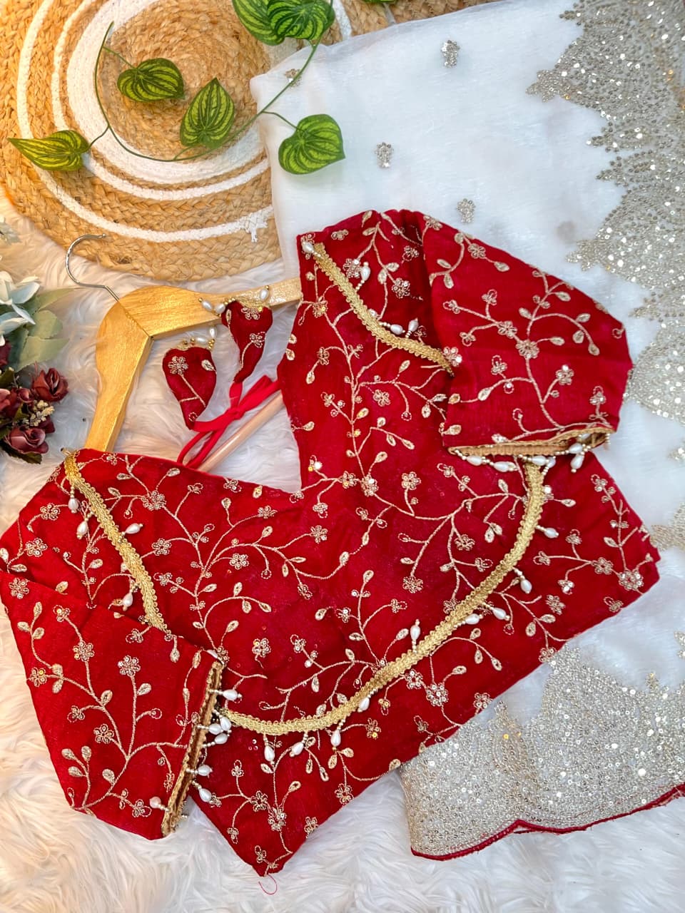 An ivory white saree featuring golden sequin embroidery and a scalloped border with red piping. Paired with a richly embroidered red blouse, the look blends elegance and sophistication, perfect for weddings or festive occasions.