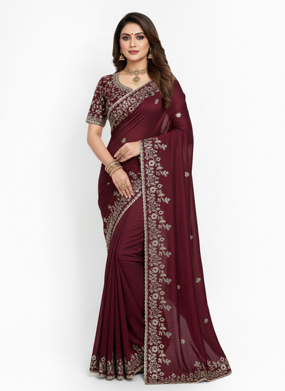 A maroon Fandy silk saree beautifully adorned with delicate floral embroidery and shimmering silver threadwork. The saree includes a matching blouse with coordinated embroidery, ideal for festive and formal occasions.