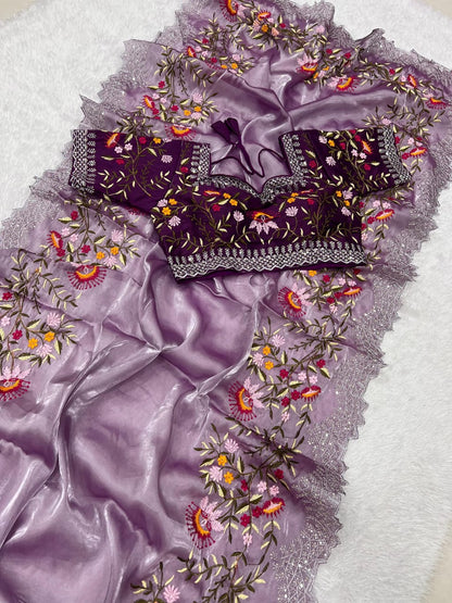 A contemporary onion pink saree featuring floral embroidery in pink, yellow, and orange tones. The saree is paired with a fully stitched embroidered blouse, creating a chic and elegant festive outfit.