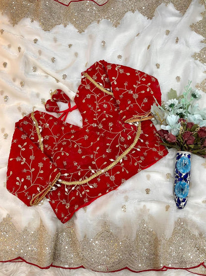 A pearl white saree embellished with fine gold sequin work and an ornate scalloped border. Styled with a deep red velvet embroidered blouse, this saree exudes a luxurious and regal charm ideal for bridal or festive wear.