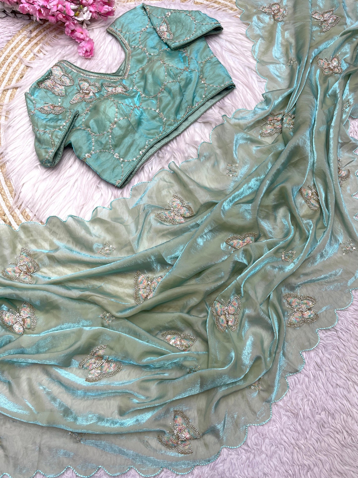 A pista green silk saree showcasing intricate sequin butterfly embroidery across the fabric and border. The saree is paired with a beautifully embroidered stitched blouse, giving it a modern yet traditional appeal.