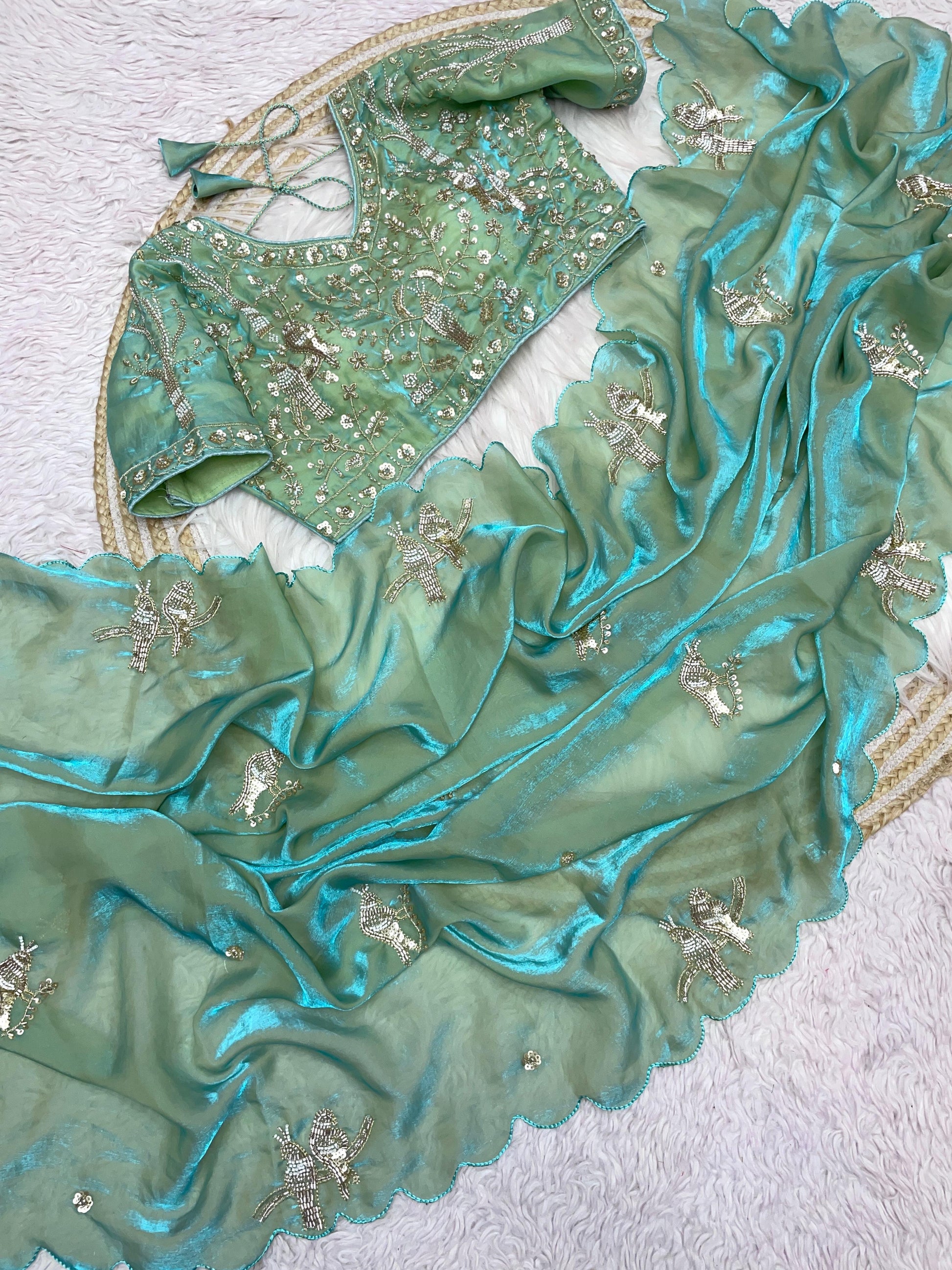 A pista green space silk saree decorated with handcrafted bird embroidery and fine sequin detailing. The ensemble includes a matching embroidered blouse, ideal for bridal and festive occasions.