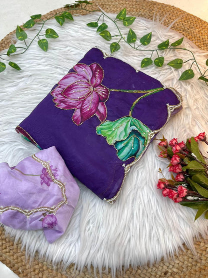 A premium soft organza saree featuring dramatic lotus-print artwork in shades of pink, green, cream, and purple. The pearl-embellished scalloped edging and matching blouse create a luxurious and eye-catching ensemble.