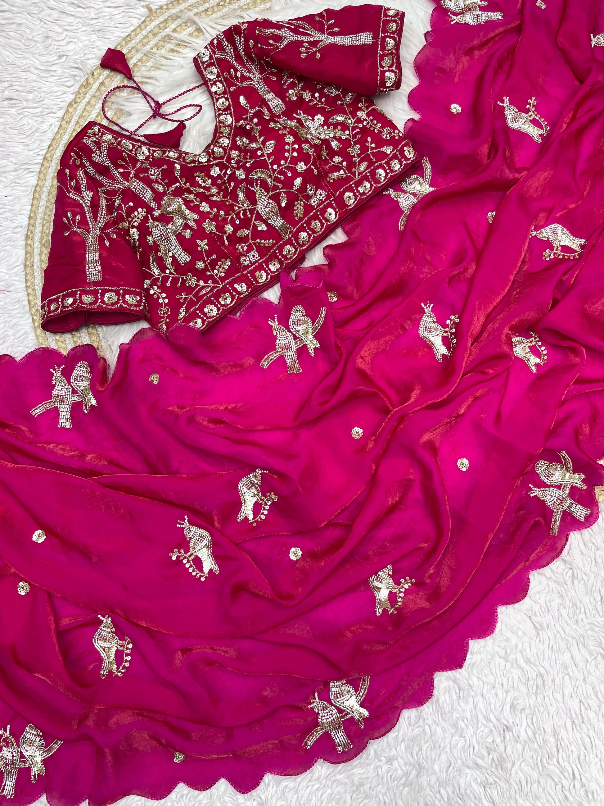 A festive Rani space silk saree adorned with handcrafted bird motifs in silver embroidery. The saree is complemented by a detailed stitched blouse, offering a perfect blend of elegance and sophistication.