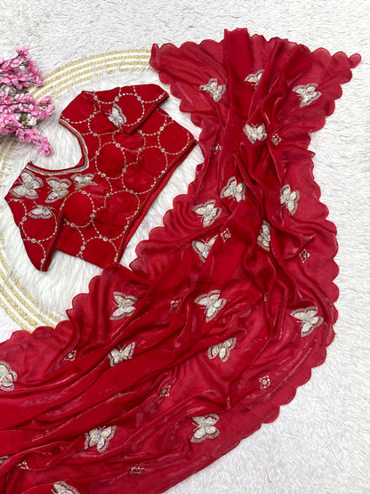 A modern red silk saree adorned with sequin butterfly embroidery and a wavy scalloped edge. The ready-to-wear blouse features matching embroidery, making this outfit a stylish choice for celebrations and parties.