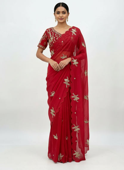 A striking red space silk saree embellished with elegant silver bird embroidery and scalloped borders. The saree is paired with a heavily embroidered stitched blouse featuring intricate zari and sequin work, creating a luxurious festive look.