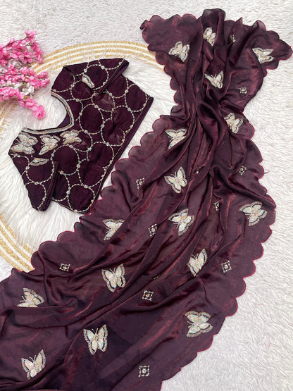 A wine-maroon space silk saree embellished with zari butterfly motifs and a wavy scalloped border. The ensemble includes a coordinating stitched blouse, creating a regal and timeless ethnic look.